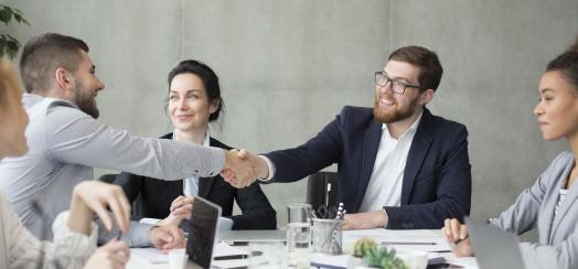 Two people shaking hands during a meeting 