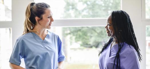 Two nurses talking near window